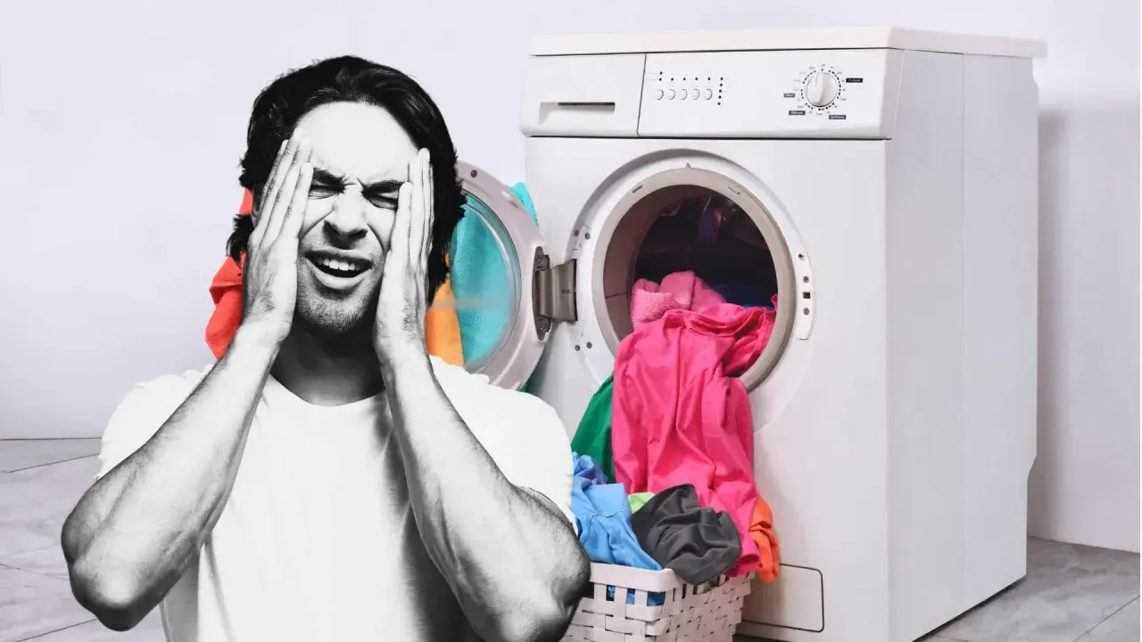 Hombre frustrado con las manos en la cara junto a una lavadora llena de ropa. ¿Por qué mi lavadora no centrifuga?