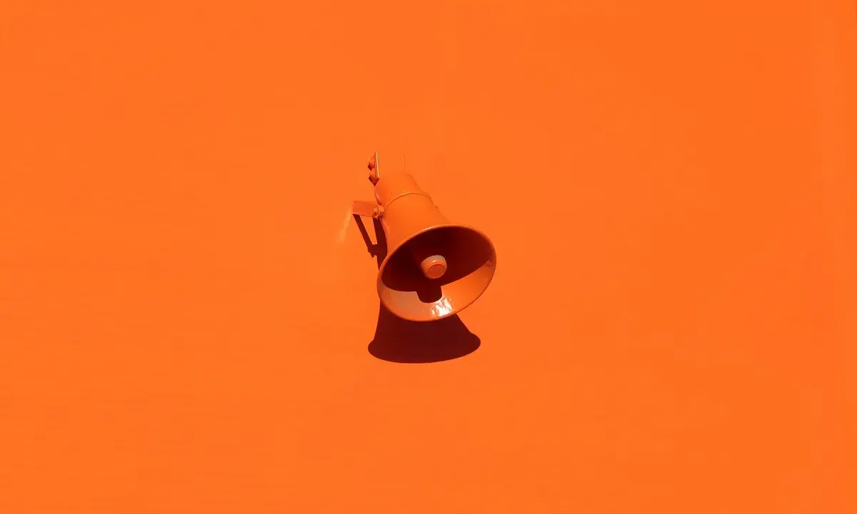 Megáfono naranja sobre fondo naranja, anunciando el fin del contrato de alquiler.