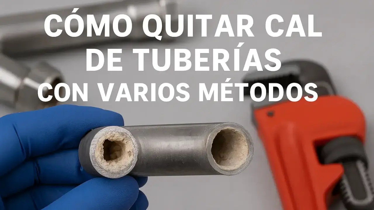 Mano enguantada muestra tubería con acumulación de cal. Llave inglesa naranja al fondo. Aprende cómo quitar cal de tuberías.