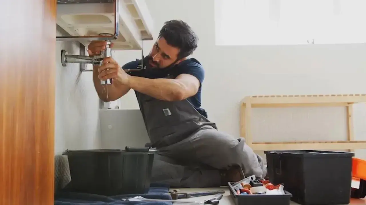 Fontanero arregla un grifo con fugas, un ejemplo de jurisprudencia sobre pequeñas reparaciones de alquiler.