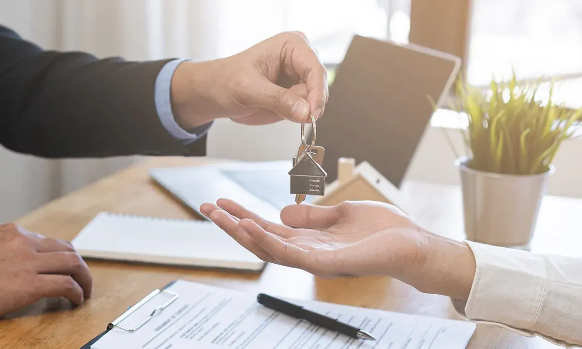 Entrega de llaves de un piso de alquiler. El agente inmobiliario da las llaves a un cliente. Ahora puedo echar a mi pareja del piso de alquiler.