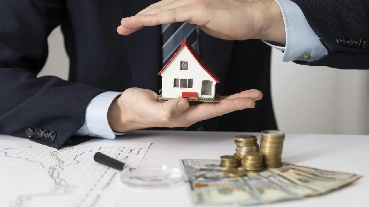 Man in suit holds a miniature house, symbolizing a **contrato de arras alquiler**. Stacks of coins and banknotes suggest financial aspects of the deal.
