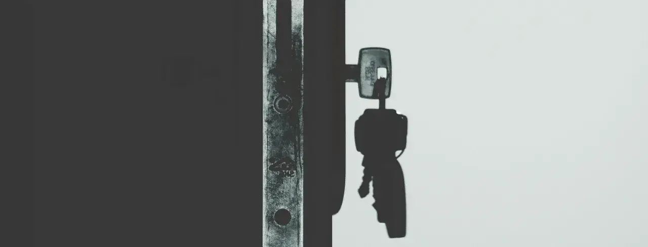 Llave de un candado en la sombra, lista para el acta de lanzamiento judicial.
