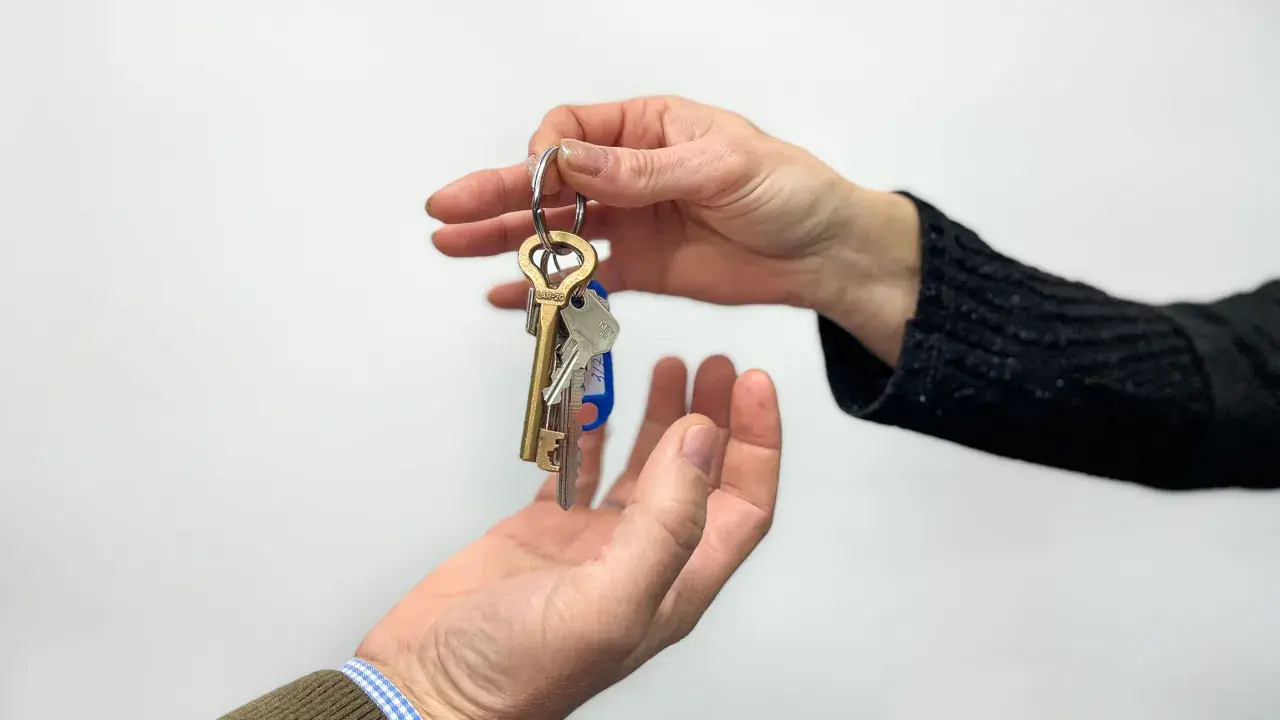 Entrega de llaves, simbolizando la posesión de una vivienda según el **articulo 8 LAU**.