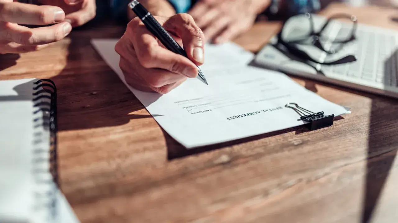 Firma de contrato de alquiler de vivienda. Se discuten los tipos de alquiler de vivienda.