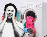 Hombre frustrado con las manos en la cara junto a una lavadora llena de ropa. ¿Por qué mi lavadora no centrifuga?
