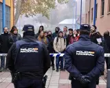 Policía Nacional vigila a un grupo de manifestantes que protestan contra un desahucio.