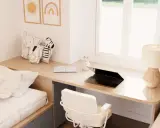 Un escritorio de madera con un portátil, libro y lámpara, junto a una cama y cojines de animales. Este es un ejemplo de cómo un **loft que es** funcional y acogedor.