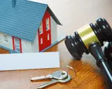 Maqueta de casa, llaves y mazo de juez, sugiriendo un lanzamiento judicial.