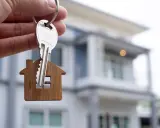 Llaves con un llavero de casa, simbolizando la compra de una vivienda, cumpliendo con el **articulo 9.3 lau**.