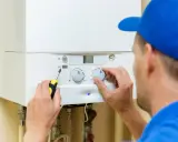 Técnico ajusta caldera. Recuerda: hay que apagar la caldera si se corta el agua para evitar daños.