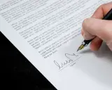 Firma de un contrato de alquiler por habitaciones, cumpliendo la normativa vigente.
