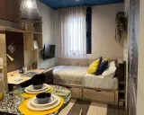 Estudio moderno en Livensa Living Madrid Aravaca con cama, escritorio, TV y mesa.