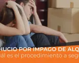 Pareja angustiada sentada entre cajas, enfrentando la enervación por desahucio fuera de plazo.