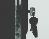Llave de un candado en la sombra, lista para el acta de lanzamiento judicial.