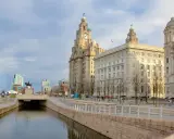 Edificios icónicos de Liverpool, incluyendo las famosas "Three Graces", se alzan majestuosos en el horizonte.