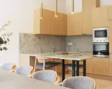 Estudio moderno en Livensa Living Studios Málaga Feria, con cocina equipada, encimera de granito y comedor con sillas cómodas.
