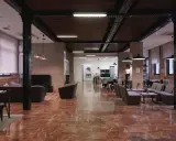 Amplio salón con suelo de mármol rojo, sofás, mesas y una mesa de billar. La **residencia diagonal** ofrece un espacio moderno y acogedor.