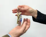 Entrega de llaves, simbolizando la posesión de una vivienda según el **articulo 8 LAU**.