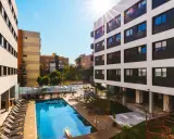 La residencia de estudiantes Livensa Living Sevilla luce su piscina y zonas comunes bajo el sol.
