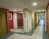 Pasillo de la residencia Laboure con puertas de madera, un ascensor y una pintura.