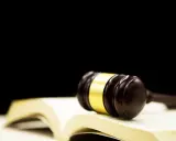 Martillo de juez sobre libro abierto. Averigua cuanto cuesta echar a un inquilino que no paga.