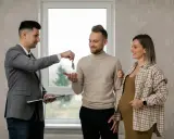 Agente inmobiliario entrega llaves a pareja embarazada. Un momento clave, como en la jurisprudencia sobre entrega de llaves.
