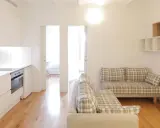 Cocina y salón modernos en la residencia Unihabit Sant Cugat. Sofás a cuadros y estanterías flotantes.