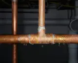 Gotitas de condensación cubren tuberías de cobre, indicando la necesidad de reparar la tubería.