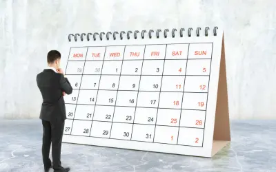 Hombre de traje frente a un calendario, pensando en el **artículo 9 de la LAU** y las fechas importantes.