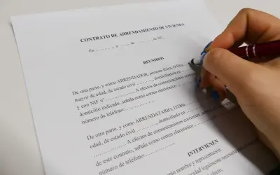 Firma de un contrato de arrendamiento de vivienda, un acuerdo legal que define los términos de alquiler.