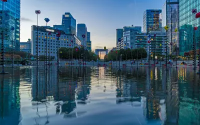 Reflejos de edificios modernos y el youfirst grande arche en un estanque.