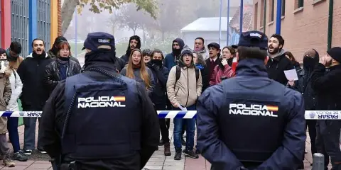 Policía Nacional vigila a un grupo de manifestantes que protestan contra un desahucio.