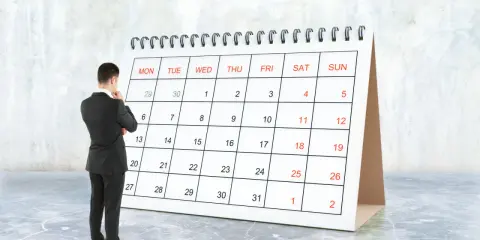 Hombre de traje frente a un calendario, pensando en el **artículo 9 de la LAU** y las fechas importantes.