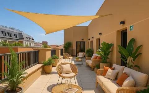 Terraza de claraval residencia con muebles de mimbre, plantas y toldo amarillo.