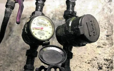 Contadores de agua, uno con esfera y otro tapado. La pregunta es quién paga el cambio de contador de agua.
