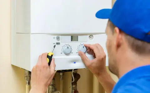 Técnico ajusta caldera. Recuerda: hay que apagar la caldera si se corta el agua para evitar daños.