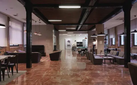 Amplio salón con suelo de mármol rojo, sofás, mesas y una mesa de billar. La **residencia diagonal** ofrece un espacio moderno y acogedor.