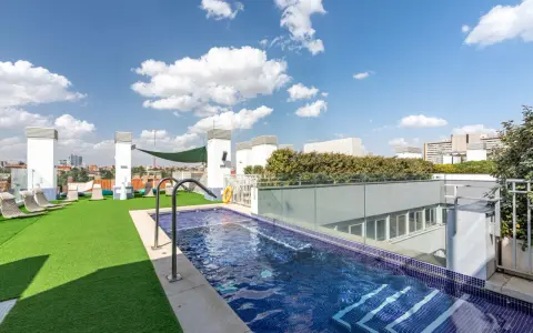 Resa Claudio Coello Madrid: piscina en azotea con césped artificial, tumbonas y vistas urbanas.