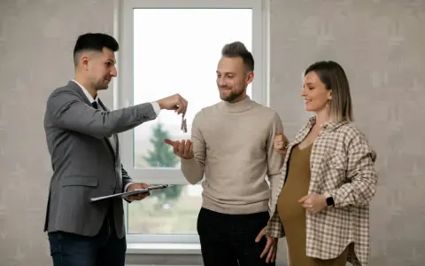 Agente inmobiliario entrega llaves a pareja embarazada. Un momento clave, como en la jurisprudencia sobre entrega de llaves.