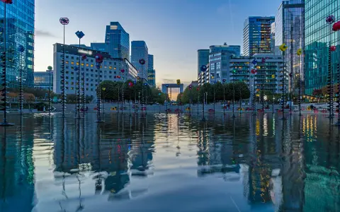 Reflejos de edificios modernos y el youfirst grande arche en un estanque.
