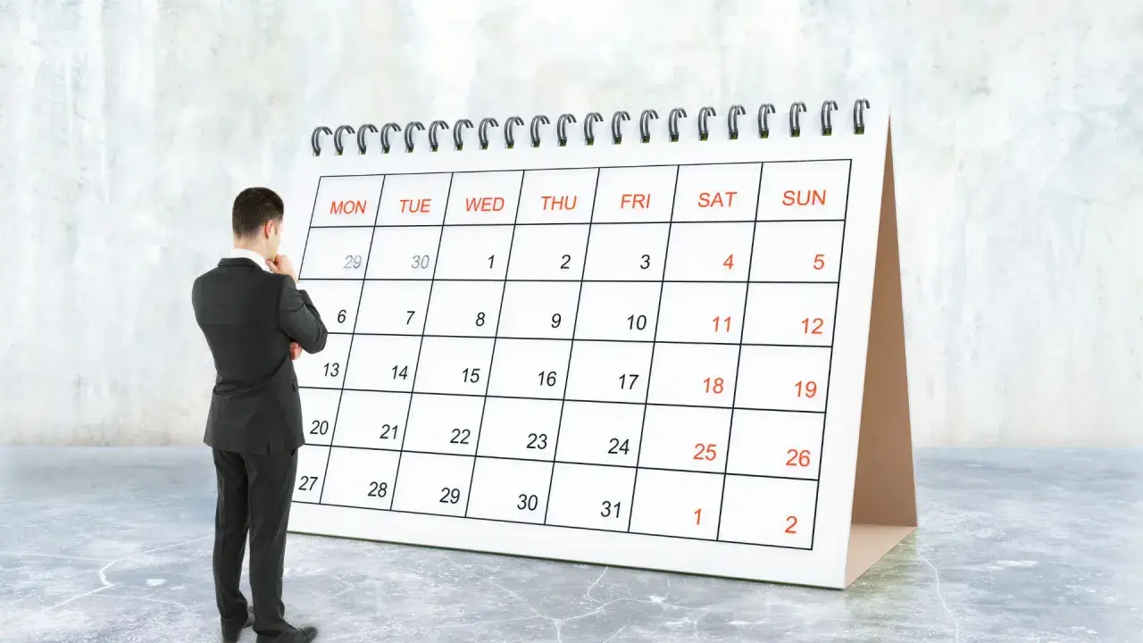 Hombre de traje frente a un calendario, pensando en el **artículo 9 de la LAU** y las fechas importantes.