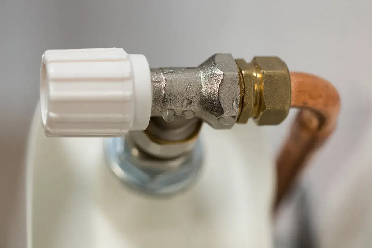 Detalle de una llave de radiador que gotea, indicando la necesidad de cambiarla.