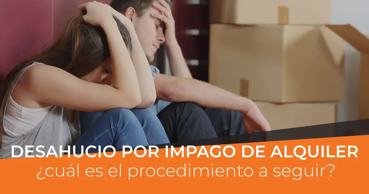 Pareja angustiada sentada entre cajas, enfrentando la enervación por desahucio fuera de plazo.