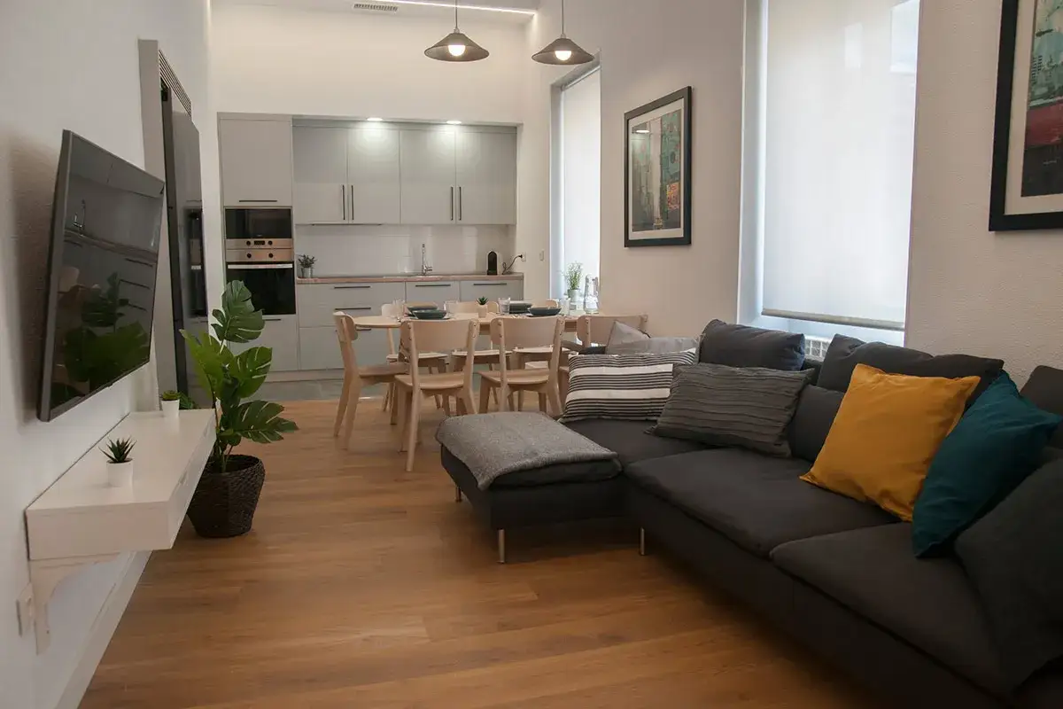 Modern living room with kitchen, dining table and sofa. Ideal for a student factory, where comfort meets functionality.