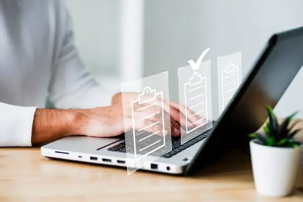 Man typing on laptop with digital checklists. It's important that es obligatorio registrar un contrato de alquiler.