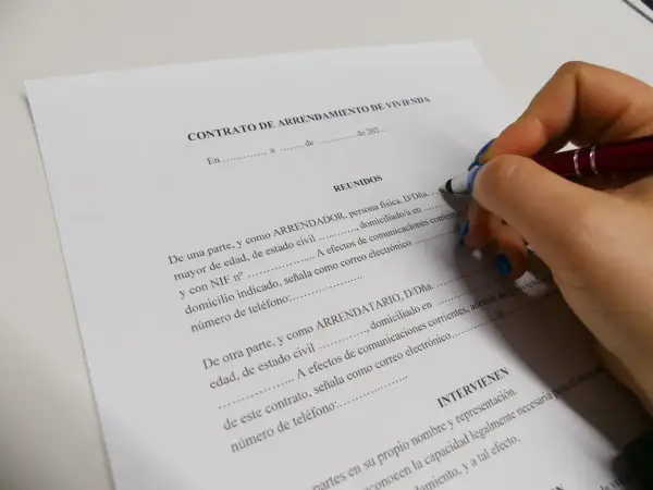 Firma de un contrato de arrendamiento de vivienda, un acuerdo legal que define los términos de alquiler.