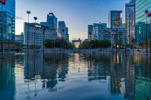 Reflejos de edificios modernos y el youfirst grande arche en un estanque.