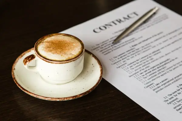 Taza de café con canela junto a un contrato, quizás revisando el artículo 27 de la LAU.
